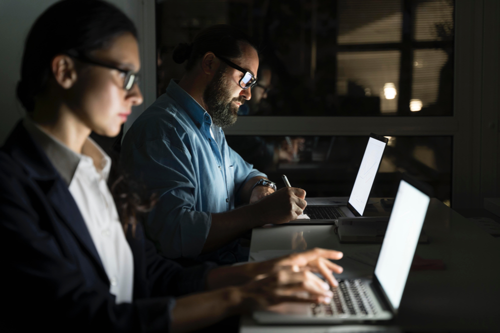 dos personas trabajando a oscuras dos personas trabajando a oscuras