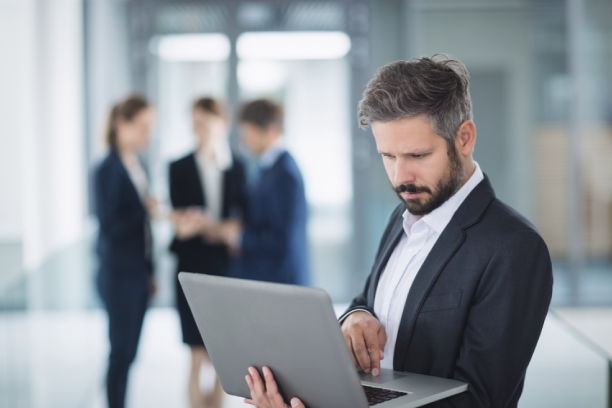 hombre de pie sosteniendo una laptop en las manos hombre de pie sosteniendo una laptop en las manos